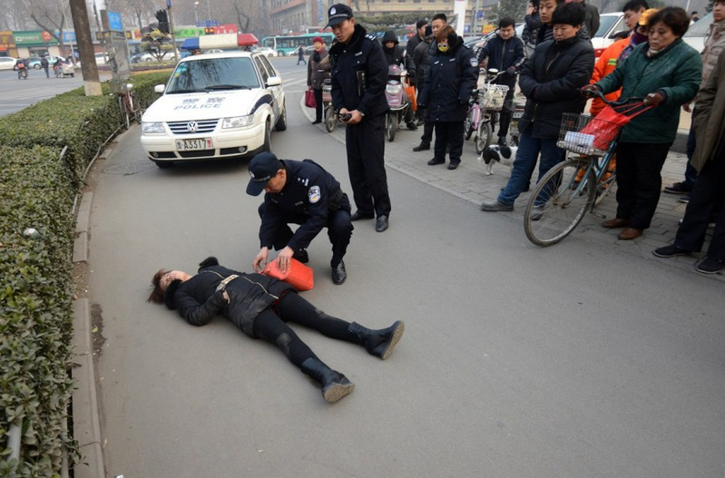 最后公安民警,急救人员,市民一起将摔倒的女子抬上担架送往医院